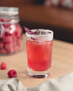 a glass of raspberry juice sitting on a table at Hotel St. George Helsinki in Helsinki