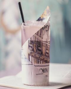 a glass filled with a dollar bill with a straw at Hotel St. George Helsinki in Helsinki