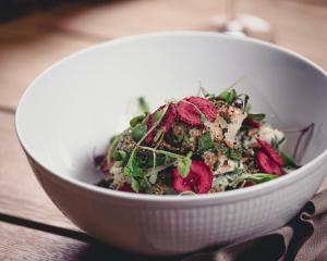 a white bowl of salad on a wooden table at Hotel St. George Helsinki in Helsinki