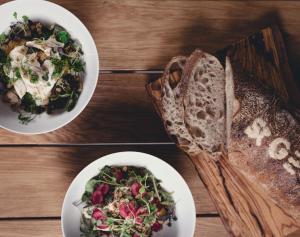 two plates of food on a wooden table with sandwiches and salad at Hotel St. George Helsinki in Helsinki