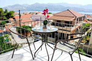 a table and chairs on a balcony with a view at Alkestis Studios in Lixouri