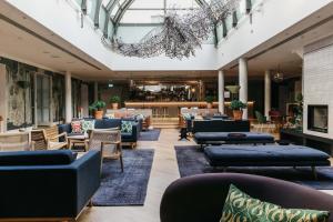 a lobby with couches and chairs and a bar at Hotel St. George Helsinki in Helsinki