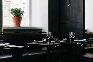 a dining room with two tables with wine glasses at Hotel St. George Helsinki in Helsinki
