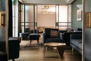 a waiting room with blue couches and a table at Hotel St. George Helsinki in Helsinki
