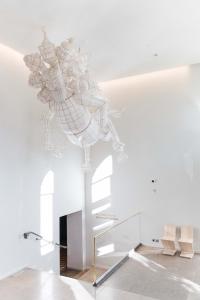 a white room with a chandelier hanging from the ceiling at Hotel St. George Helsinki in Helsinki