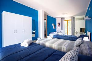 a bedroom with blue walls and two beds at Rocca degli Etnei in Paterno