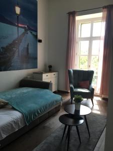 um quarto com uma cama, uma cadeira e uma mesa em Balkon Apartman Horváth Ház Balatonfüred em Balatonfüred