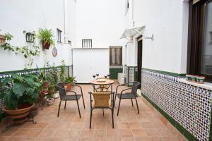 Un balcón con mesa y sillas y plantas. en Rodrigo de Triana Courtyard by Valcambre, en Sevilla