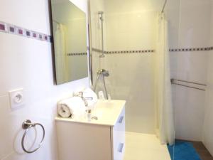 a bathroom with a sink and a shower with a mirror at La petite Maison in Grenoble