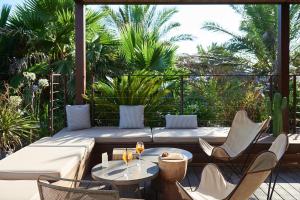 a patio with a couch and chairs and a table at Nova Lodges in Grimaud