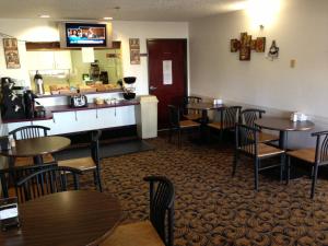 a restaurant with tables and chairs and a bar at Brentwood Inn & Suites in Hobbs