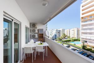 ポルティマンにあるEdificio Sol Matos Apartmentのバルコニー(白いテーブルと椅子、大きな窓付)