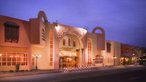 a large building with a store on a street at night at Bel Air Azur Resort (Adults Only) in Hurghada