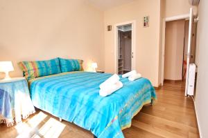 セビリアにあるRodrigo de Triana Courtyard by Valcambreのベッドルーム1室(青い毛布付きのベッド1台付)