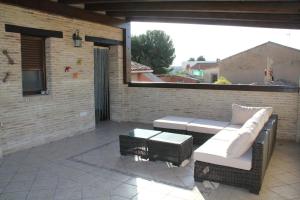 un patio con sofá, mesa y ventana en Casa Rural Maria Isabel, en Puigmoreno