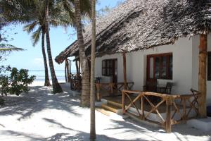 マテムウェにあるPanga Chumvi Beach Resortのヤシの木が植えられた浜辺の家