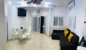 salon z czarną kanapą i stołem w obiekcie Apartament Benalmadena Puerto Marina w mieście Benalmádena
