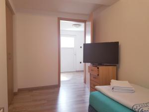 a bedroom with a flat screen tv and a bed at Kleine Pension in Garstedt