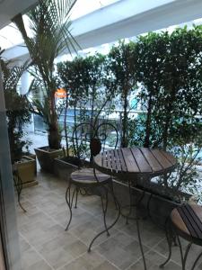 een tafel en stoelen op een patio met uitzicht op de oceaan bij Cafe de Paris in Patong Beach