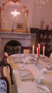 a dining room with a table with candles and a fireplace at Hartley House B&B in Carrick on Shannon