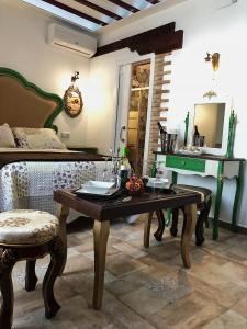 een woonkamer met een tafel en een bed bij RETIRO DEL TEATRO Hotel Boutique y Apartamentos en Almagro in Almagro