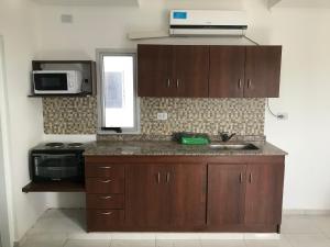 a kitchen with a sink and a microwave at Edificio Tomy in Charata