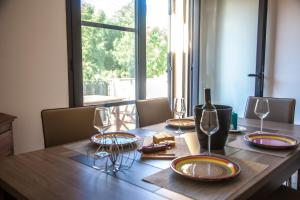 a wooden table with plates and wine glasses on it at Sardinian Gallery Temo in Bosa