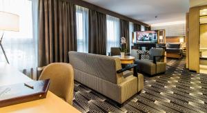 a hotel room with a couch and chairs and a television at Airport Hotel Okęcie in Warsaw