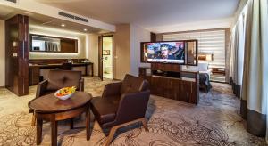 a hotel room with a television and a living room at Airport Hotel Okęcie in Warsaw