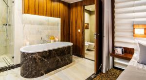 a bathroom with a bath tub and a toilet at Airport Hotel Okęcie in Warsaw