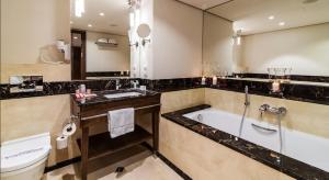 a bathroom with a tub and a toilet and a sink at Airport Hotel Okęcie in Warsaw