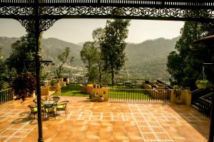 an outdoor patio with a view of a mountain at The Fern Hillside Resort Bhimtal in Bhīm Tāl
