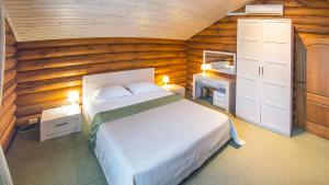 1 dormitorio con 1 cama en una habitación de madera en Russkaya Okhota Hotel, en Kurumoch