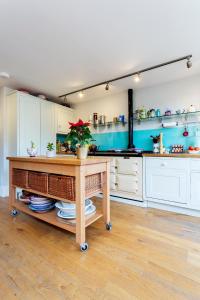a kitchen with white cabinets and a table with a plant at Veeve - Parliament Hill Townhouse in London
