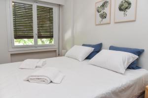uma cama branca com almofadas brancas e uma janela em Modern Apartment at Exarchia 1 bed 2 pers em Atenas
