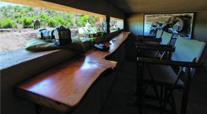 - une longue table en bois dans une chambre avec caméra dans l'établissement Tuningi Safari Lodge, à Madikwe Game Reserve