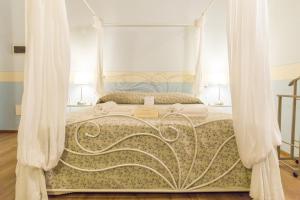 a bedroom with a canopy bed with white curtains at Agriturismo e Agricamping Le Nosare in Valeggio sul Mincio