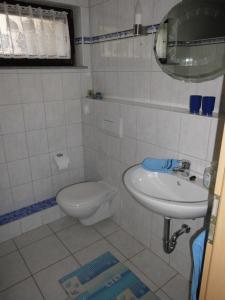 biała łazienka z toaletą i umywalką w obiekcie Ferienwohnung Christa Rohde w mieście Bad Münder am Deister