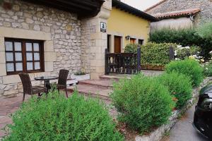 a patio with two chairs and a table in front of a house at Trisileja en Posada La Busta in La Busta