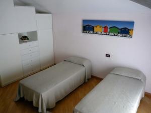 a bedroom with two beds and a painting on the wall at Appartamento 1 in Pineto