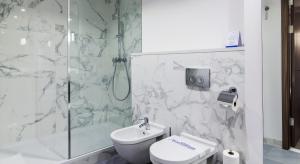 a bathroom with a shower and a toilet and a sink at Airport Hotel Okęcie in Warsaw