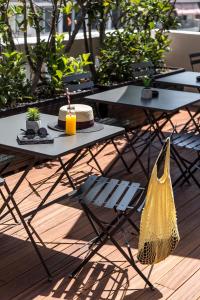 a table and chairs with a hat and a yellow purse at The Modernist Thessaloniki in Thessaloniki