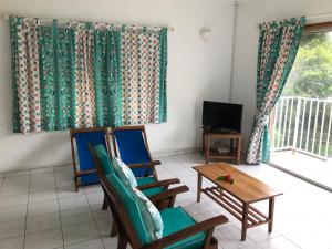 a living room with two chairs and a table and a tv at Michel Holiday Apartments in Victoria