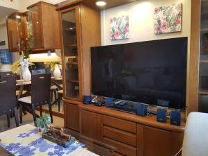 ein großes Entertainment-Center mit einem großen Flachbild-TV in der Unterkunft KC 2-Bedroom 1 at Horizon 101 Cebu in Cebu City