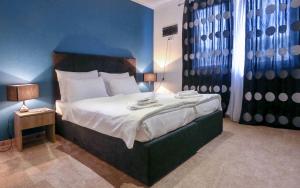 a bedroom with a large bed with a blue wall at ESHE Boutique Hotel in Sarajevo