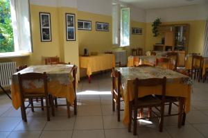 a dining room with tables and chairs with yellow walls at Ostello Residenza Molinatto in Oggiono