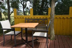 une table et des chaises sur une terrasse avec une clôture jaune dans l'établissement Countryside Eco Natuurhuisjes, à Ee