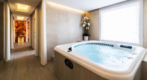a large bath tub in a bathroom with a window at Airport Hotel Okęcie in Warsaw