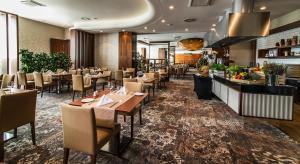 a restaurant with tables and chairs and a bar at Airport Hotel Okęcie in Warsaw