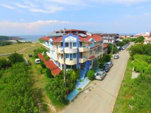 a building on the side of a street next to a road at Family Hotel Sinemoretz in Sinemorets